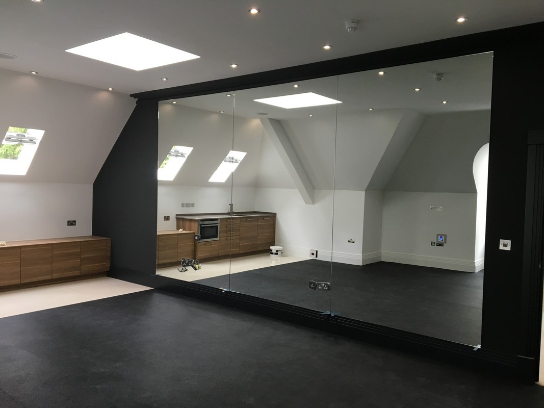Frameless glass wall dividing loft conversion in High Wycombe